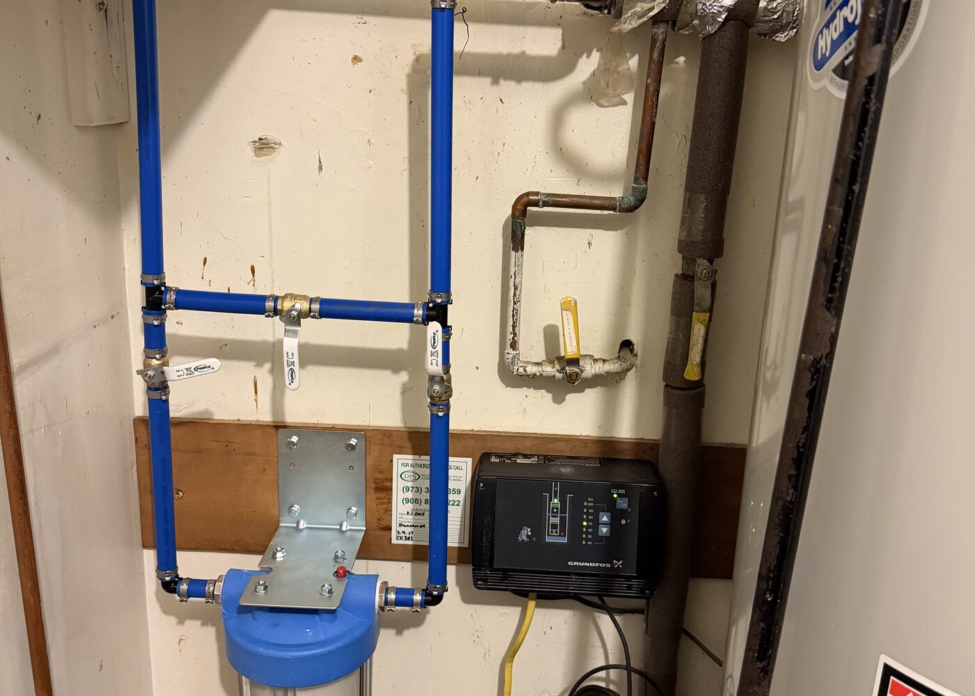 Water filtration system and blue PEX piping installed near a water heater
